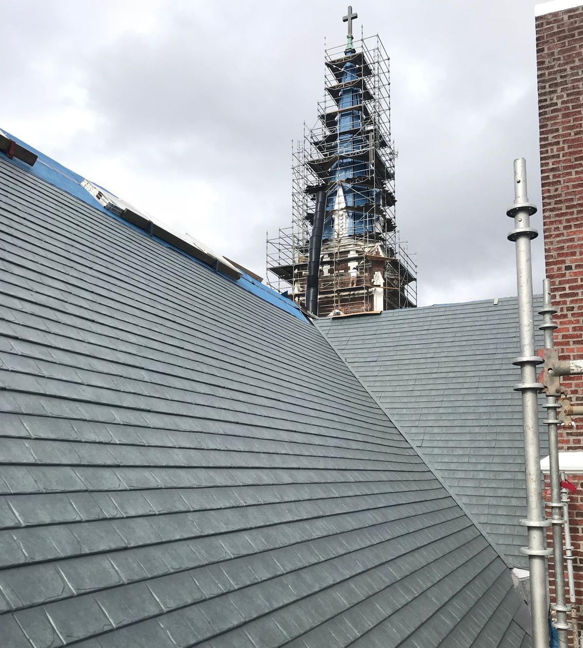 A roof of a building with a clock tower in the background